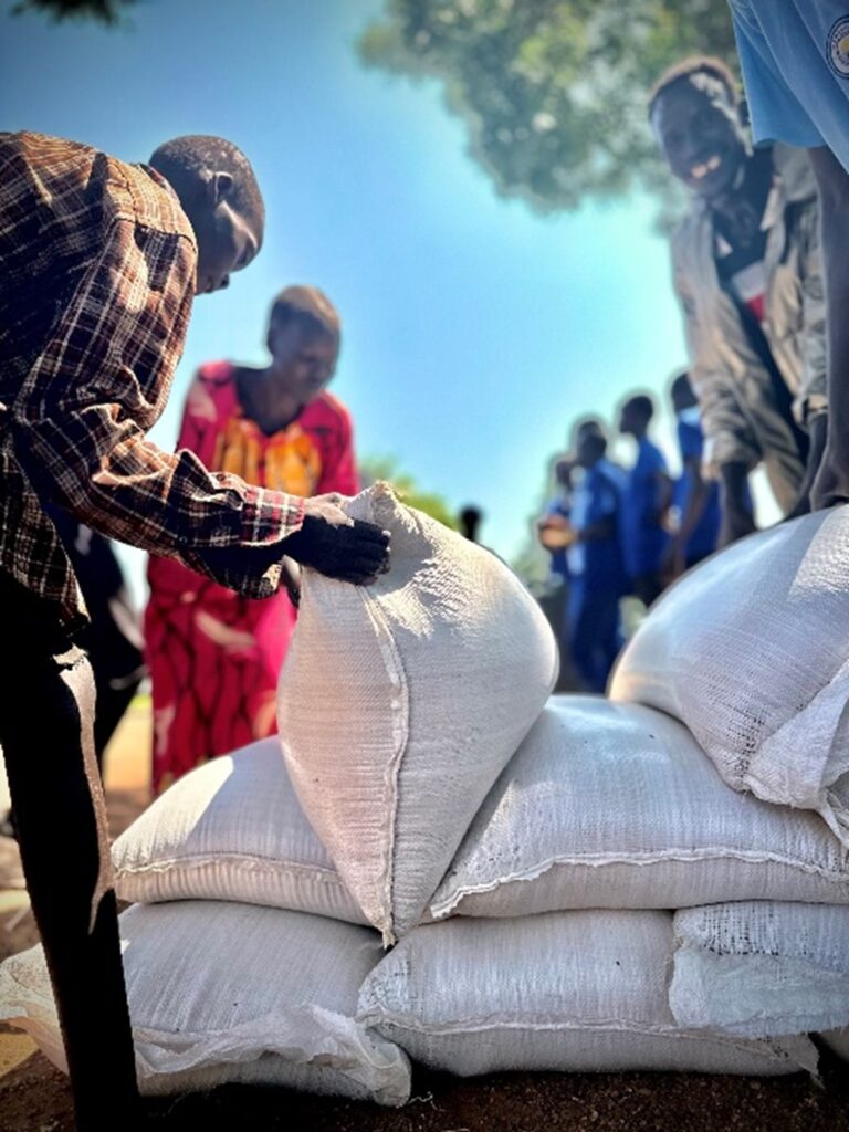 Villagers picking up bags of food