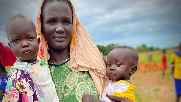 A lady holding two kids