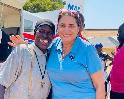 Suzy and Sister Mary embracing in front of a MAF airplane