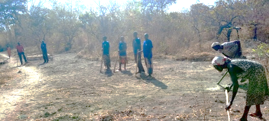 A group of people standing in a field after clearing grass.